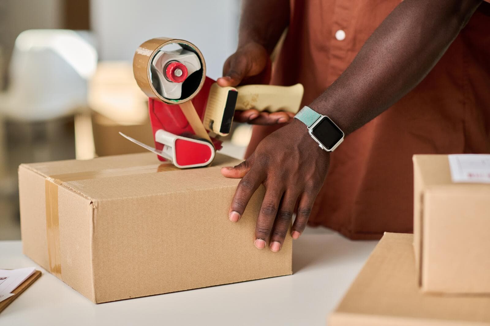 Hands taping up a parcel